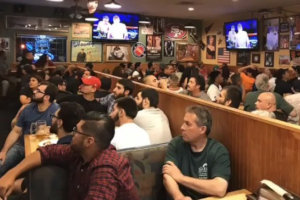 Crowded restaurant watching a sporting event on the television sets